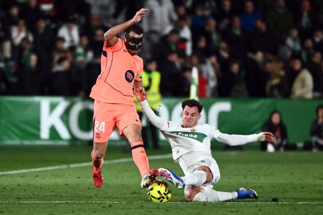TOPSHOT - Barcelona's Spanish defender #24 Eric Garcia and Elche's Spanish forward #11 German Valera fight for the ball during the Spanish league football match between Elche CF and FC Barcelona at thge Martinez Valero stadium in Elche on January 31, 2026. (Photo by JOSE JORDAN / AFP)