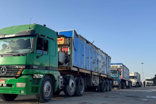 Trucks transporting portable toilets and humanitarian aid wait to enter through the Egyptian side of the Rafah border crossing with the Gaza Strip in northeastern Egypt on February 1, 2026. Israel partially reopened the Rafah crossing between the devastated Gaza Strip and Egypt on February 1, following months of urging from humanitarian organisations, though access is limited to the movement of people. (Photo by AFP)