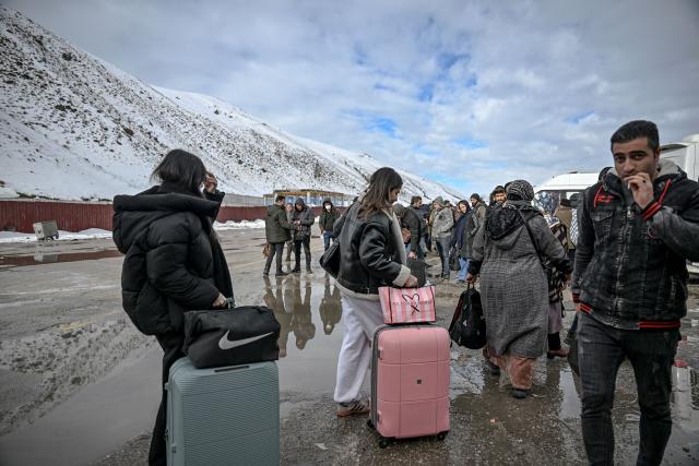 TOPSHOT - Iranian nationals arrive in Turkey through the Razi-Kapiköy border crossing, north-eastern Turkey on February 1, 2026. Iran's supreme leader Ayatollah Ali Khamenei warned on February 1, 2026 of a "regional war" if the United States attacked following heavy military deployments by Washington in the Gulf. (Photo by Ozan KOSE / AFP)