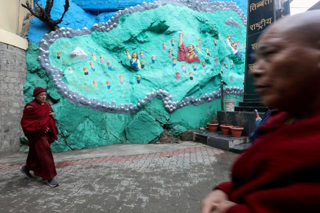 Buddhist monks walk past the Tibetan National Martyrs' Memorial during an election in Dharamsala, headquarters of the Tibetan government-in-exile, on February 1, 2026. Exiled Tibetans began a unique global election on February 1 for a government representing a homeland many have never seen, as part of a democratic exercise voters say carries great weight. (Photo by Sanjay BAID / AFP)