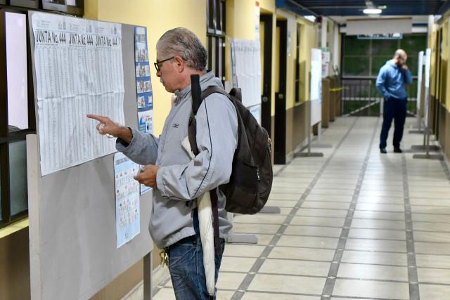Voters look up their polling station in the electoral register during the presidential election, in San Antonio de Escazu, San Jose province, on February 1, 2026. Costa Rica, a beacon of stability in Central America that is battling a surge in violence related to drug trafficking, goes to the polls on February 1 in elections that are expected to bring a tough-on-crime right-winger to power. (Photo by EZEQUIEL BECERRA / AFP)