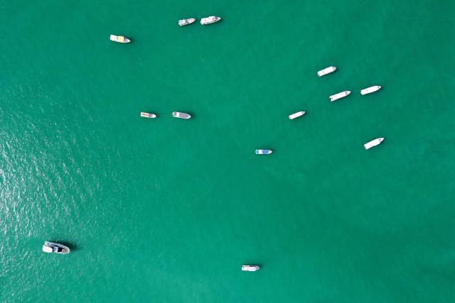 An aerial view shows fishing boats in the Gulf waters of Kuwait City on February 1, 2026. (Photo by YASSER AL-ZAYYAT / AFP)
