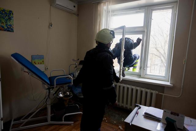 A rescue worker clears debris in a damaged maternity hospital following a Russian strike in Zaporizhzhia on February 1, 2026, amid the Russian invasion of Ukraine. Russian attacks on Ukraine overnight and early on February 1, 2026 killed at least two people and injured seven others, regional authorities said. (Photo by Tetiana DZHAFAROVA / AFP)