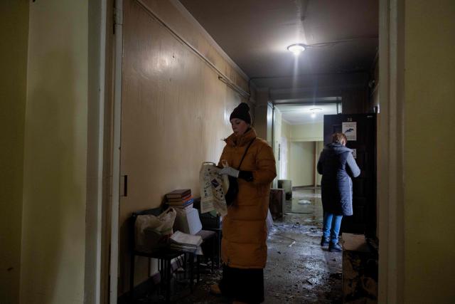 A woman with a bag is standing in a damaged maternity hospital following a Russian strike in Zaporizhzhia on February 1, 2026, amid the Russian invasion of Ukraine. Russian attacks on Ukraine overnight and early on February 1, 2026 killed at least two people and injured seven others, regional authorities said. (Photo by Tetiana DZHAFAROVA / AFP)