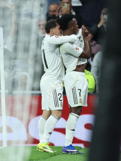 Real Madrid's Brazilian forward #07 Vinicius Junior (R) celebrates scoring the opening goal during the Spanish league football match between Real Madrid CF and Rayo Vallecano at the Santiago Bernabeu stadium in Madrid on February 1, 2026. (Photo by Thomas COEX / AFP)