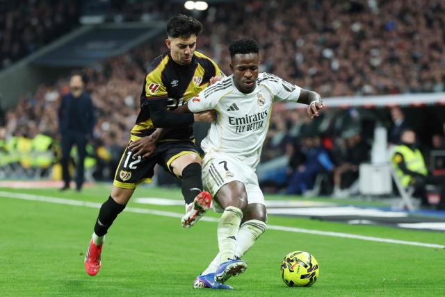 Rayo Vallecano's Moroccan forward #12 Ilias Akhomach and Real Madrid's Brazilian forward #07 Vinicius Junior fight for the ball during the Spanish league football match between Real Madrid CF and Rayo Vallecano at the Santiago Bernabeu stadium in Madrid on February 1, 2026. (Photo by Thomas COEX / AFP)