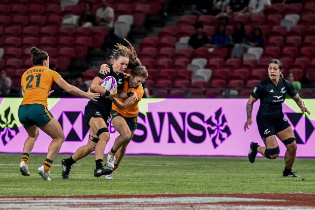 New Zealand's Olive Watherston (2L) fights for the ball against team Australia during the women's final event at the HSBC Rugby Sevens Singapore tournament in the National Stadium of Singapore on February 1, 2026. (Photo by Roslan RAHMAN / AFP)
