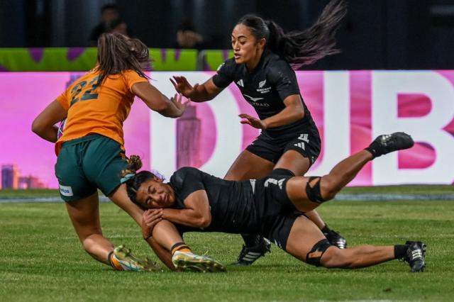 New Zealand's Risaleaana Pouri-Lane (C) fights against Australia's Bienne Terita (L) during the women's final event at the HSBC Rugby Sevens Singapore tournament in the National Stadium of Singapore on February 1, 2026. (Photo by Roslan RAHMAN / AFP)