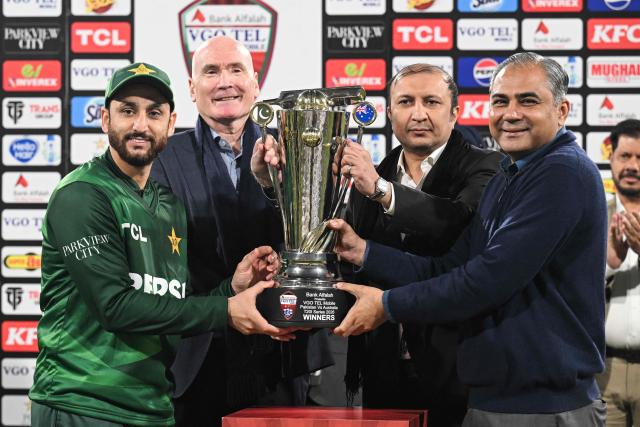 Pakistan's captain Salman Agha (L) receives the trophy from Pakistan Cricket Board (PCB) chairman Mohsin Naqvi (R) after his team's win at the end of the third Twenty20 international cricket match between Pakistan and Australia at the Gaddafi Stadium in Lahore on February 1, 2026. (Photo by Arif ALI / AFP)