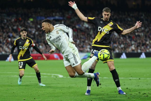 TOPSHOT - Rayo Vallecano's French defender #24 Florian Lejeune (R) and Real Madrid's French forward #10 Kylian Mbappe fight for the ball during the Spanish league football match between Real Madrid CF and Rayo Vallecano at the Santiago Bernabeu stadium in Madrid on February 1, 2026. (Photo by Thomas COEX / AFP)