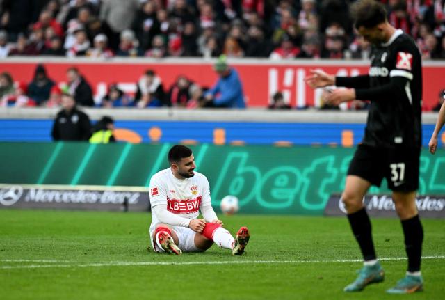 Stuttgart's German forward #26 Deniz Undav (L) sits on the pitch and reacts after he failed to score during the German first division Bundesliga football match between VfB Stuttgart and SC Freiburg in Stuttgart, southern Germany, on February 1, 2026. (Photo by THOMAS KIENZLE / AFP) / DFL REGULATIONS PROHIBIT ANY USE OF PHOTOGRAPHS AS IMAGE SEQUENCES AND/OR QUASI-VIDEO