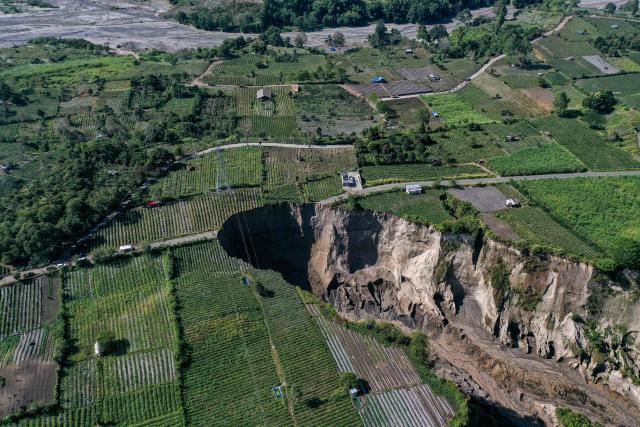 An aerial view shows the site of a ground collapse owing to landsliding at the Pondok Balik village in Ketol district, Aceh province on February 1, 2026. (Photo by Fadly / AFP)