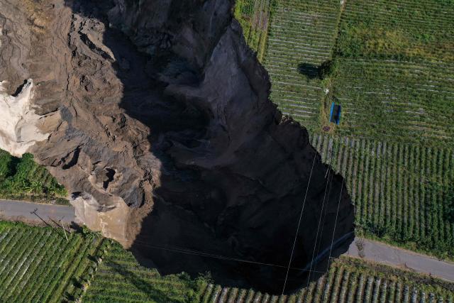 An aerial view shows the site of a ground collapse owing to landsliding at the Pondok Balik village in Ketol district, Aceh province on February 1, 2026. (Photo by Fadly / AFP)