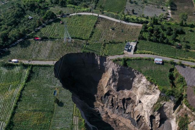 An aerial view shows the site of a ground collapse owing to landsliding at the Pondok Balik village in Ketol district, Aceh province on February 1, 2026. (Photo by Fadly / AFP)