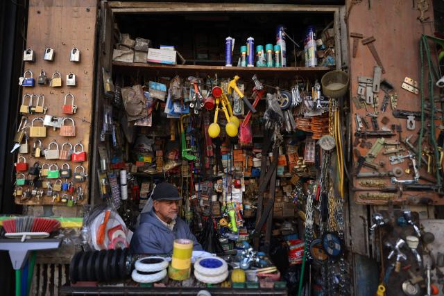 An Iraqi man sits inside a construction materials store in the Al-Ukaidad market on Al-Rashid Street in central Baghdad on February 1, 2026. (Photo by AHMAD AL-RUBAYE / AFP)