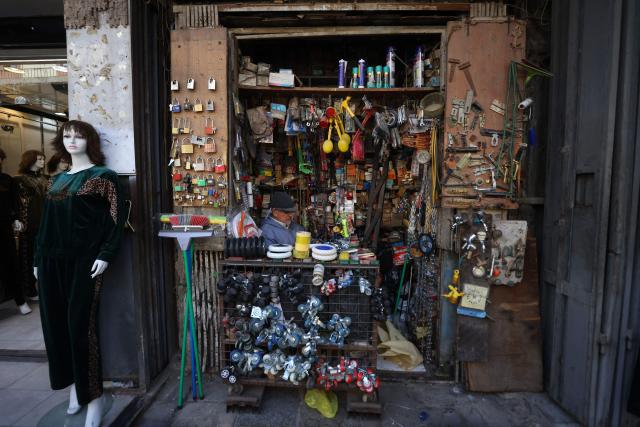 An Iraqi man sits inside a construction material store in the Al-Ukaidad market on Al-Rashid Street in central Baghdad on February 1, 2026. (Photo by AHMAD AL-RUBAYE / AFP)