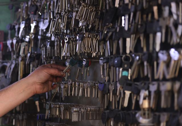 An Iraqi man holds one of the keys inside his key-making workshop in the Al-Ukaidad market on Al-Rashid Street in central Baghdad on February 1, 2026. (Photo by AHMAD AL-RUBAYE / AFP)