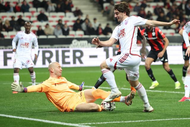 Brest's French midfielder #13 Joris Chotard (R) fights for the ball with Nice's French goalkeeper #31 Maxime Dupe (L) during the French L1 football match between OGC Nice and Stade Brestois 29 (Brest) at the Allianz Riviera Stadium in Nice, south-eastern France, on February 1, 2026.  (Photo by Valery HACHE / AFP)