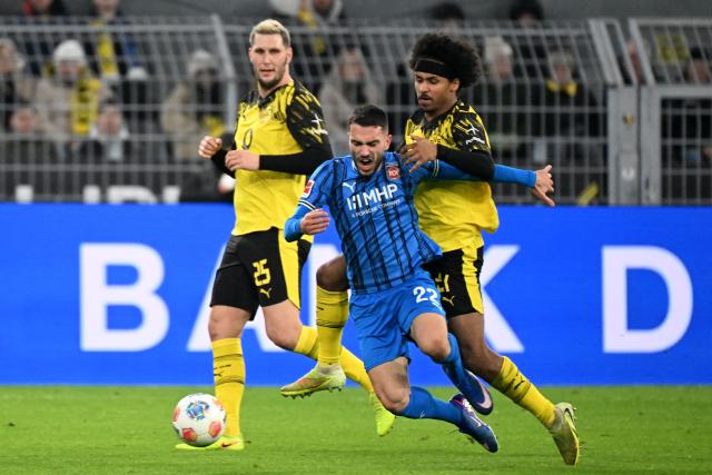 Heidenheim's German-Kosovan midfielder #22 Arijon Ibrahimovic (C) vies for the ball wih Dortmund's German defender #25 Niklas Suele (L) and Dortmund's German forward #27 Karim Adeyemi during the German first division Bundesliga football match between Borussia Dortmund and Heidenheim in Dortmund, western Germany, on February 1, 2026. (Photo by UWE KRAFT / AFP) / DFL REGULATIONS PROHIBIT ANY USE OF PHOTOGRAPHS AS IMAGE SEQUENCES AND/OR QUASI-VIDEO