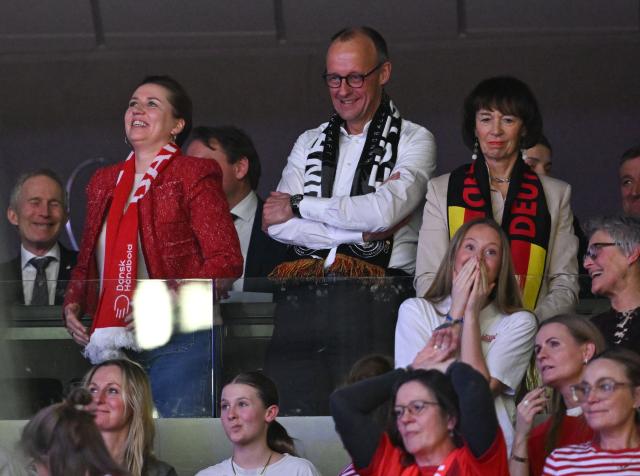 German Chancellor Friedrich Merz (back row C), his wife Charlotte Merz (R) and Danish Prime Minister Mette Frederiksen react as they watch from the stands the Men's EHF Euro 2026 final handball match Denmark vs Germany in Herning, Denmark, on February 1, 2026. (Photo by Jonathan Nackstrand / AFP)