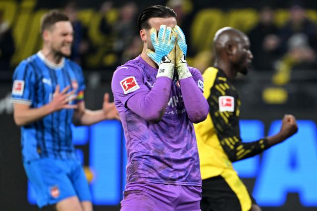Dortmund's Guinean forward #09 Serhou Guirassy (back R) celebrates after scoring a goal past Heidenheim's German goalkeeper #41 Diant Ramaj (front C) during the German first division Bundesliga football match between Borussia Dortmund and Heidenheim in Dortmund, western Germany, on February 1, 2026. (Photo by UWE KRAFT / AFP) / DFL REGULATIONS PROHIBIT ANY USE OF PHOTOGRAPHS AS IMAGE SEQUENCES AND/OR QUASI-VIDEO