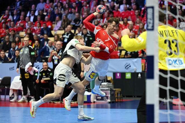 Germany's left back #13 Matthes Langhoff (L) and Denmark's wing #07 Emil Manfeldt Jakobsen vie for the ball during the Men's EHF Euro 2026 final handball match Denmark vs Germany in Herning, Denmark, on February 1, 2026. (Photo by Jonathan Nackstrand / AFP)