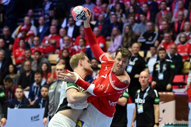 Germany's left back #13 Matthes Langhoff (L) and Denmark's wing #07 Emil Manfeldt Jakobsen vie for the ball during the Men's EHF Euro 2026 final handball match Denmark vs Germany in Herning, Denmark, on February 1, 2026. (Photo by Jonathan Nackstrand / AFP)