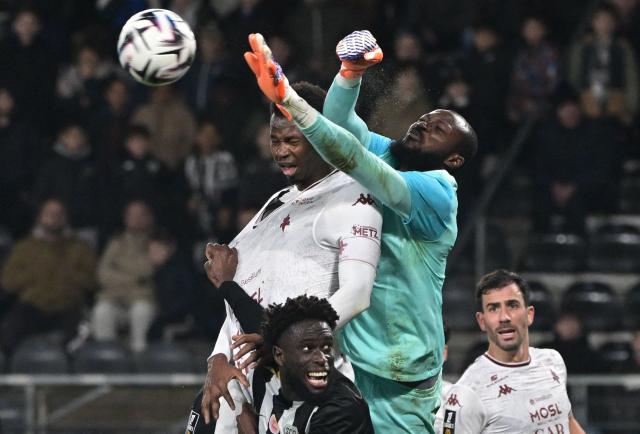 Metz's Senegalese forward #30 Habib Diallo (L) fights for the ball with Angers' Burkinabe goalkeeper #12 Herve Koffi during the French L1 football match between SCO Angers and FC Metz at the Stade Raymond-Kopa in Angers on February 1, 2026. (Photo by Damien Meyer / AFP)