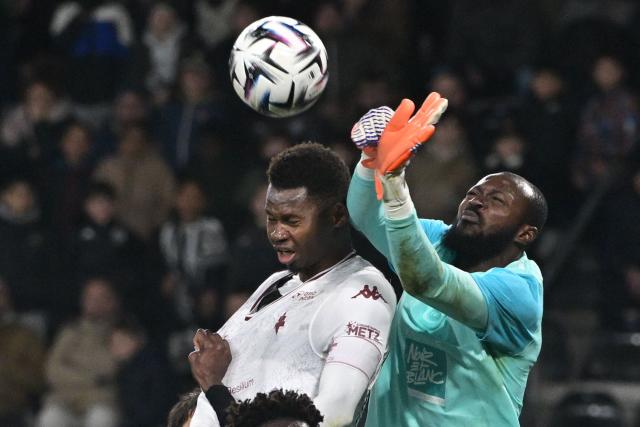 Metz's Senegalese forward #30 Habib Diallo (L) fights for the ball with Angers' Burkinabe goalkeeper #12 Herve Koffi during the French L1 football match between SCO Angers and FC Metz at the Stade Raymond-Kopa in Angers on February 1, 2026. (Photo by Damien Meyer / AFP)