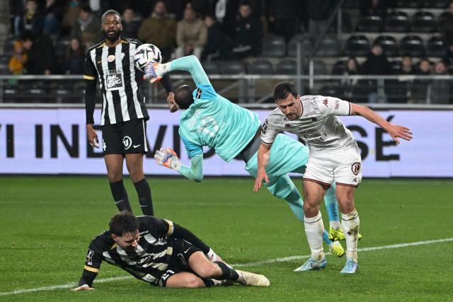 Angers' Burkinabe goalkeeper #12 Herve Koffi (C) fights for the ball with Metz's French defender #02 Maxime Colin (R) during the French L1 football match between SCO Angers and FC Metz at the Stade Raymond-Kopa in Angers on February 1, 2026. (Photo by Damien Meyer / AFP)