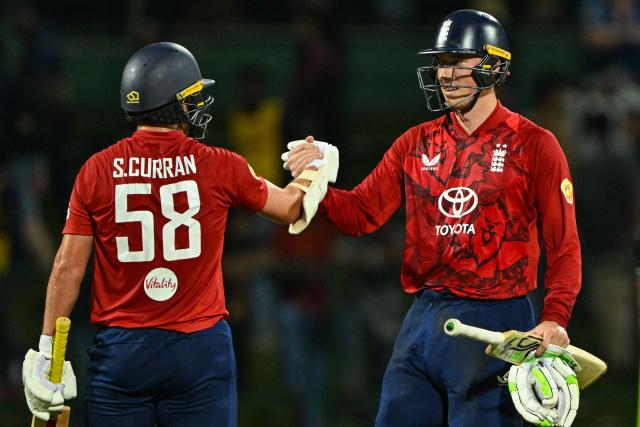 England's Tom Banton (R) and Sam Curran celebrates after winning during the second Twenty20 international cricket match between Sri Lanka and England at the Pallekele International Cricket Stadium in Kandy on February 1, 2026. (Photo by Ishara S. KODIKARA / AFP)