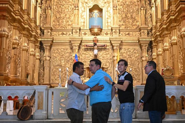 Human rights activist Javier Tarazona (2-L) is greeted by with his brother Jose Rafael Tarazona (2-R) and lawyers Miguel Forero (R) and Omar de Dios Garcia after his release from prison at La Candelaria church in Caracas on February 1, 2026. Renowned Venezuelan human rights activist Javier Tarazona was freed on February 1st after more than four years in prison on charges including terrorism and treason, his brother told AFP. (Photo by Federico PARRA / AFP)