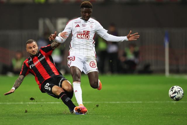 Nice's French defender #92 Jonathan Clauss (L) fights for the ball with Brest's Senegalese forward #99 Pathe Mboup (R) during the French L1 football match between OGC Nice and Stade Brestois at the Allianz Riviera Stadium in Nice, south-eastern France, on February 1, 2026. (Photo by Valery HACHE / AFP)