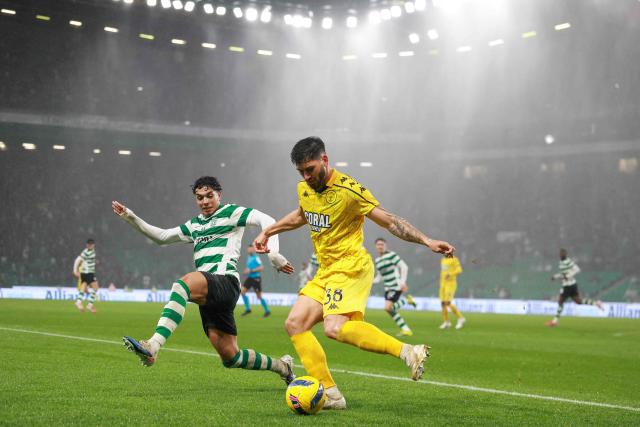 Nacional's Brazilian defender #38 Ze Vitor (R) controls the ball challenged by Sporting Lisbon's Portuguese midfielder #52 Joao Simoes during the Portuguese League football match between Sporting CP and CD Nacional da Madeira at the Jose Alvalade stadium in Lisbon on February 1, 2026. (Photo by PATRICIA DE MELO MOREIRA / AFP)