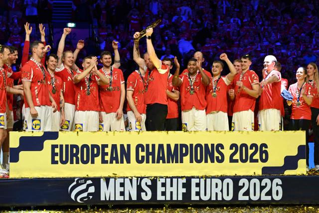 Denmark's coach Nikolaj Jacobsen (C) holds up the trophy as Denmark's team celebrates winning the Men's EHF Euro 2026 final handball match Denmark vs Germany in Herning, Denmark, on February 1, 2026. (Photo by Jonathan Nackstrand / AFP)