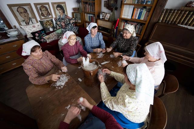 Women tear feathers into small pieces during the traditional feather plucking in Kobyli, South Moravia, on February 1, 2026. In Kobyli, women gather to pluck feathers from geese and ducks by hand. For over twenty years, women have been meeting every winter to follow this tradition. (Photo by Radek MICA / AFP)