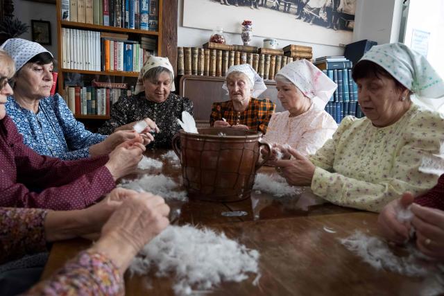 Women tear feathers into small pieces during the traditional feather plucking in Kobyli, South Moravia, on February 1, 2026. In Kobyli, women gather to pluck feathers from geese and ducks by hand. For over twenty years, women have been meeting every winter to follow this tradition. (Photo by Radek MICA / AFP)