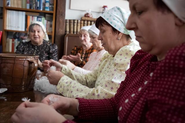 Women tear feathers into small pieces during the traditional feather plucking in Kobyli, South Moravia, on February 1, 2026. In Kobyli, women gather to pluck feathers from geese and ducks by hand. For over twenty years, women have been meeting every winter to follow this tradition. (Photo by Radek MICA / AFP)