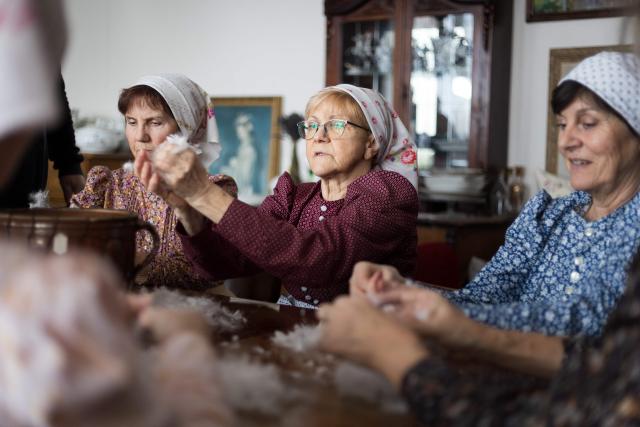 Women tear feathers into small pieces during the traditional feather plucking in Kobyli, South Moravia, on February 1, 2026. In Kobyli, women gather to pluck feathers from geese and ducks by hand. For over twenty years, women have been meeting every winter to follow this tradition. (Photo by Radek MICA / AFP)