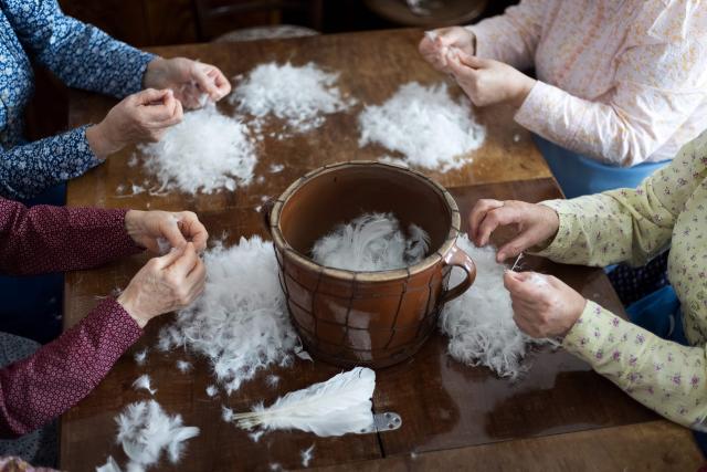 Women tear feathers into bits during the traditional feather plucking in Kobyli, South Moravia, on February 1, 2026. In Kobyli, women gather to pluck feathers from geese and ducks by hand. For over twenty years, women have been meeting every winter to follow this tradition. (Photo by Radek MICA / AFP)