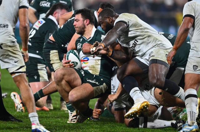 Pau's Argentinian number eight Facundo Isa (C) is tackled during the French Top14 rugby union match between Section Paloise Bearn Pyrenees (Pau) and Racing Club Toulon at Stade du Hameau stadium in Pau, south-western France on February 1, 2026. (Photo by Gaizka IROZ / AFP)