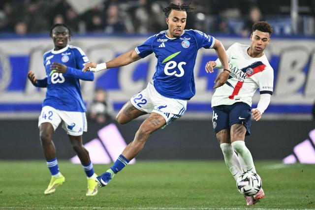 Strasbourg's Ivorian defender #22 Guela Doue fights for the ball with Paris Saint-Germain's French midfielder #14 Desire Doue during the French L1 football match between RC Strasbourg Alsace and Paris Saint-Germain (PSG) at the Stade de la Meinau in Strasbourg, eastern France, on February 1, 2026. (Photo by SEBASTIEN BOZON / AFP)