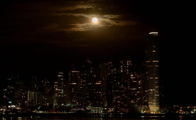 This view shows the skyline with the full moon in the background in Panama City on February 1, 2026. (Photo by MARTIN BERNETTI / AFP)