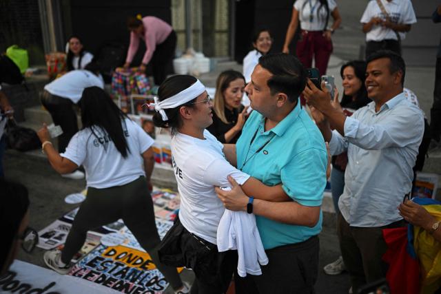 Human rights activist Javier Tarazona (C, right) greets relatives of political prisoners during a demonstration demanding their release outside the El Helicoide building, headquarters of the Bolivarian National Intelligence Service (SEBIN), in Caracas on February 1, 2026. Renowned Venezuelan human rights activist Javier Tarazona was freed on February 1st after more than four years in prison on charges including terrorism and treason, his brother told AFP. (Photo by Federico PARRA / AFP)