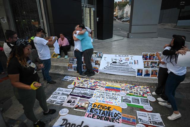 Human rights activist Javier Tarazona (C, right) greets relatives of political prisoners during a demonstration demanding their release outside the El Helicoide building, headquarters of the Bolivarian National Intelligence Service (SEBIN), in Caracas on February 1, 2026. Renowned Venezuelan human rights activist Javier Tarazona was freed on February 1st after more than four years in prison on charges including terrorism and treason, his brother told AFP. (Photo by Federico PARRA / AFP)