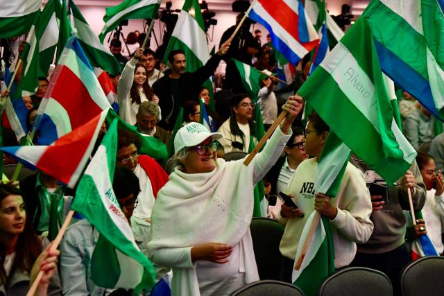 Supporters of Costa Rica’s presidential candidate from the Liberation Party, Alvaro Ramos, wave flags as they wait for the results of the presidential election at the Crowne Plaza Corobici hotel in San Jose on February 1, 2026. (Photo by EZEQUIEL BECERRA / AFP)