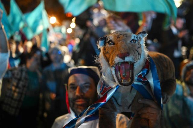 A supporter of Costa Rica’s presidential candidate from the Sovereign People Party, Laura Fernandez, shows a stuffed tiger toy as he waits for the results of the presidential election outside the Aurola Hotel in San Jose on February 1, 2026. Voters in Costa Rica, a beacon of stability in Central America threatened by a surge in drug-related violence, went to the polls in general elections that are expected to bring a tough-on-crime right-winger to power. (Photo by MARVIN RECINOS / AFP)