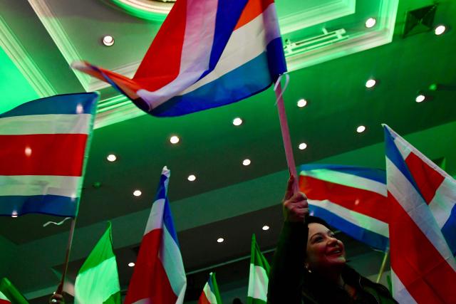 A supporter of Costa Rica’s presidential candidate from the Liberation Party, Alvaro Ramos, waves a national flag as she waits for the results of the presidential election at the Crowne Plaza Corobici hotel in San Jose on February 1, 2026. Voters in Costa Rica, a beacon of stability in Central America threatened by a surge in drug-related violence, went to the polls in general elections that are expected to bring a tough-on-crime right-winger to power. (Photo by EZEQUIEL BECERRA / AFP)