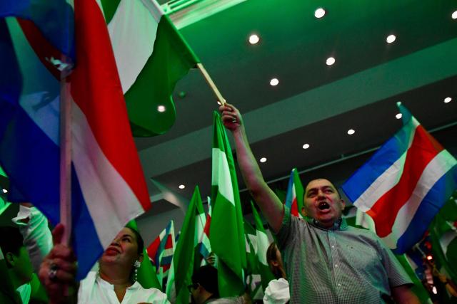 Supporters of Costa Rica’s presidential candidate from the Liberation Party, Alvaro Ramos, wave flags as they wait for the results of the presidential election at the Crowne Plaza Corobici hotel in San Jose on February 1, 2026. Voters in Costa Rica, a beacon of stability in Central America threatened by a surge in drug-related violence, went to the polls in general elections that are expected to bring a tough-on-crime right-winger to power. (Photo by EZEQUIEL BECERRA / AFP)