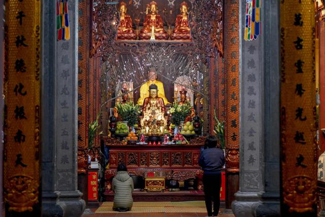 Worshippers pray before Buddha figures at a pagoda in Hanoi on February 2, 2026. (Photo by Nhac NGUYEN / AFP)
